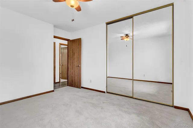 a view of an empty room with a ceiling fan