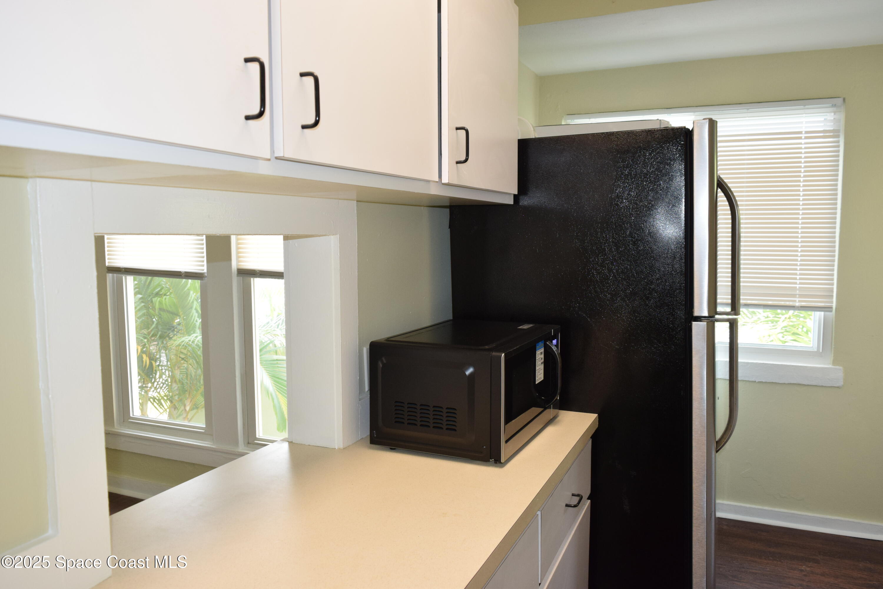 658 Young Street, Unit 2 Melbourne, FL 32935 - Photo 9 of 15 a kitchen with a refrigerator and cabinets