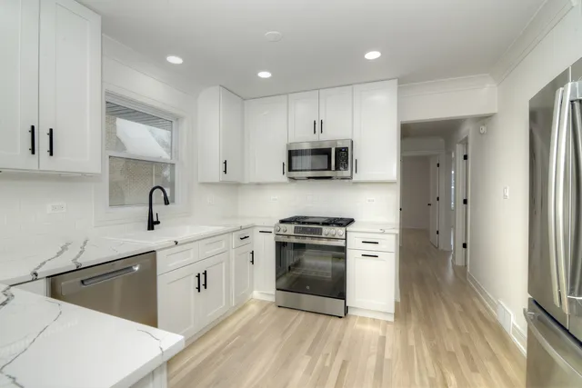 a kitchen with stainless steel appliances granite countertop a sink stove and refrigerator