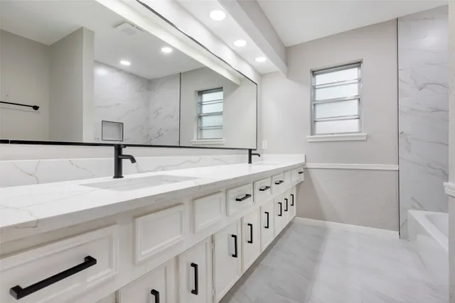 a bathroom with double sink and a mirror