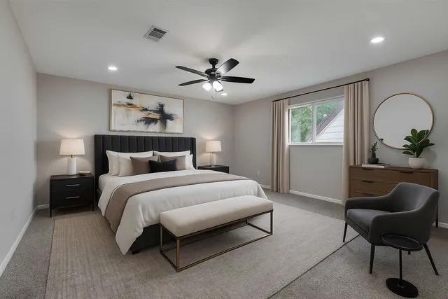 a bedroom with a bed a couch and a potted plant