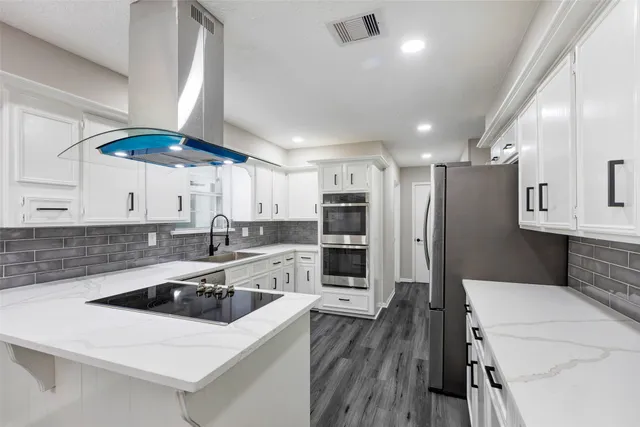 a kitchen with stainless steel appliances a sink a refrigerator a table and chairs