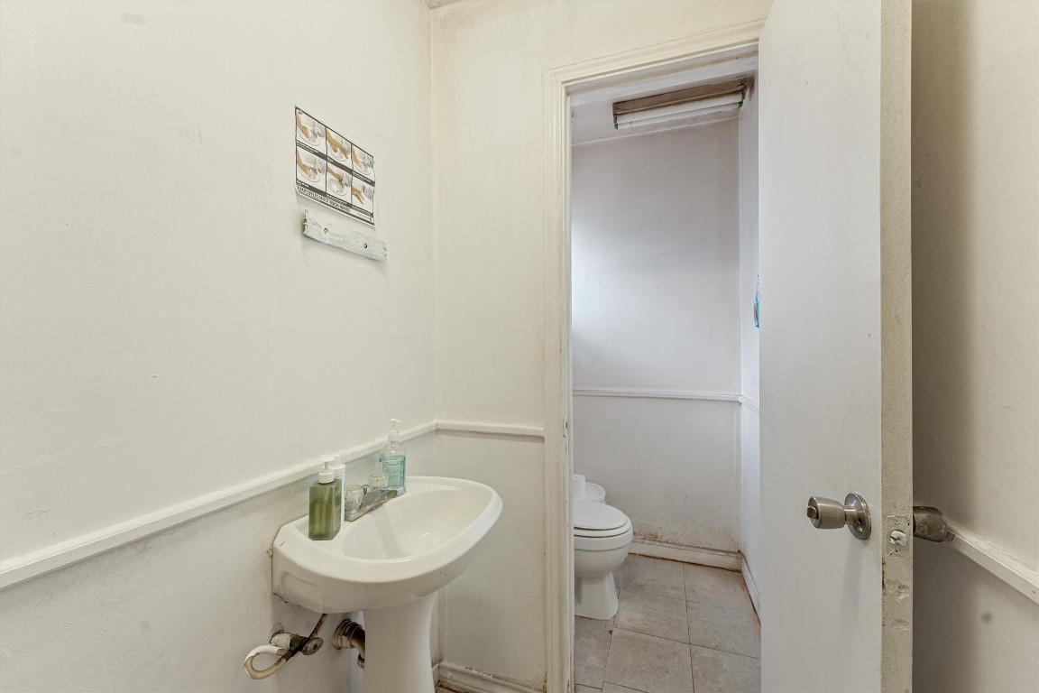 2915 Kashmere Street Houston, TX 77026 - Photo 13 of 20 a bathroom with a toilet a sink and a mirror