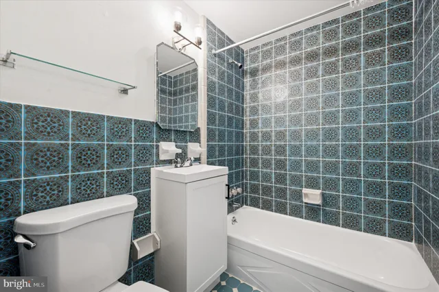 a bathroom with a sink a toilet a mirror and shower