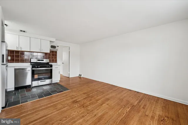 a kitchen with granite countertop a stove a sink and a refrigerator