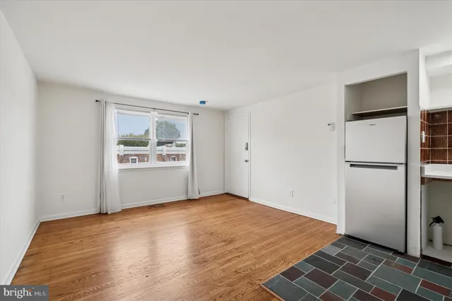 a view of a kitchen with wooden floor and a hallway