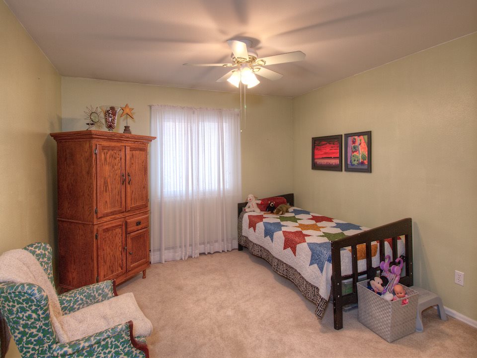 2949 Erika Road Grand Junction, CO 81504 - Photo 12 of 20 a bedroom with a bed and a chandelier