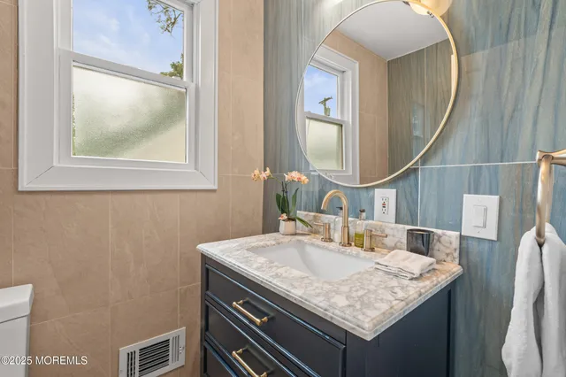 a bathroom with a granite countertop sink and a mirror