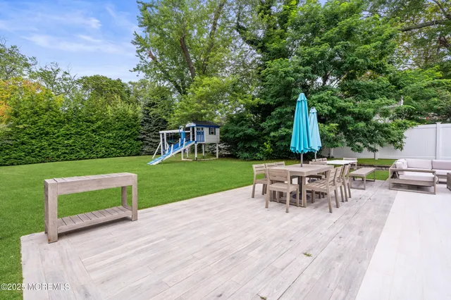 a view of a patio with table and chairs potted plants and a palm tree