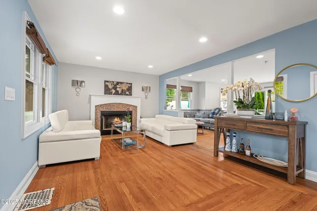 a living room with furniture a fireplace and a large mirror