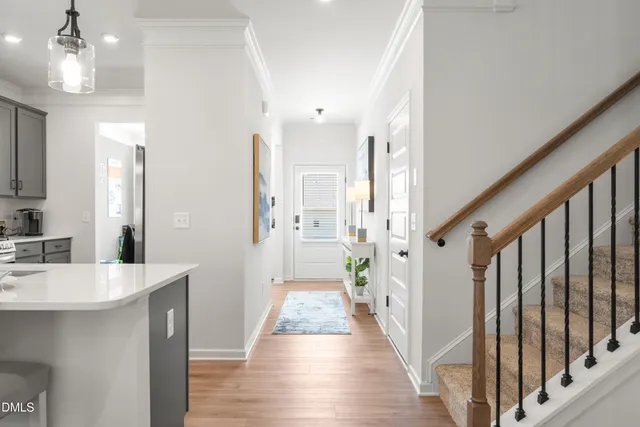 a view of a hallway with wooden floor and staircase