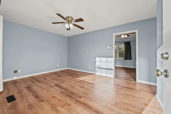 a view of a livingroom with wooden floor and a ceiling fan