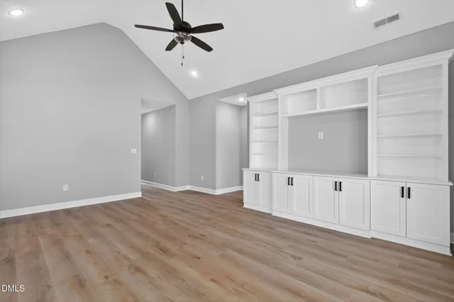 a view of an empty room with wooden floor