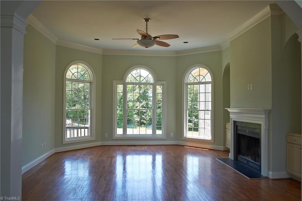 602 Bobcat Road Summerfield, NC 27358 - Photo 12 of 30 Open and bright living room with a beautiful view of the natural 10 acres. Original hardwood floors and wood burning fireplace.