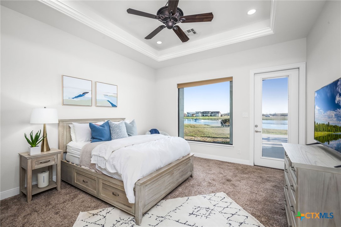 925 River Ranch Circle Martindale, TX 78655 - Photo 27 of 48 a bedroom with a bed a dresser and a chandelier
