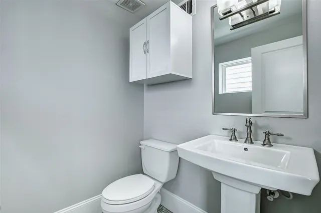 a view of an empty room with wooden floor and a ceiling fan