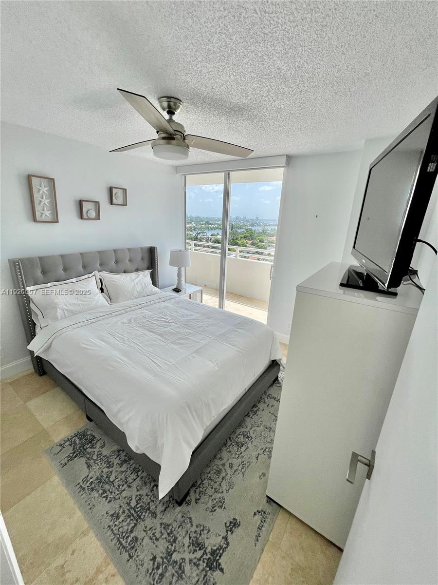 8911 Collins Avenue, Unit 1201 Surfside, FL 33154 - Photo 11 of 27 a bedroom with a bed and a large window