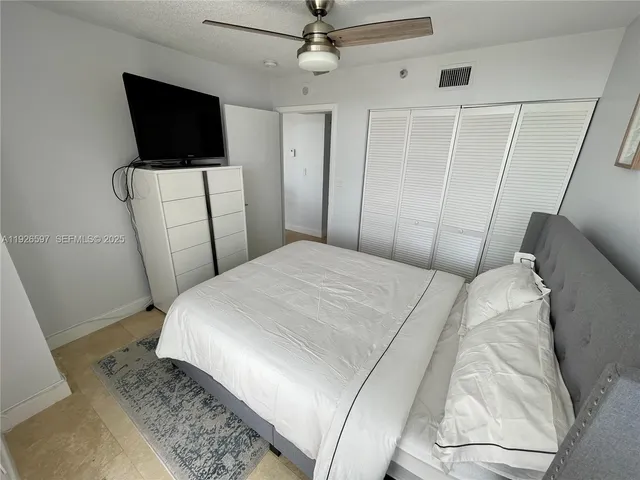 a bedroom with a bed a flat screen tv and a couch
