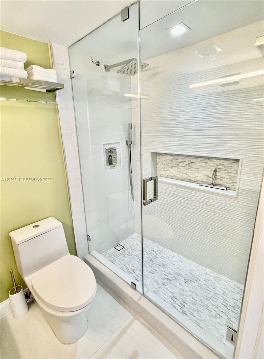 8911 Collins Avenue, Unit 1201 Surfside, FL 33154 - Photo 15 of 27 a bathroom with a toilet and a shower