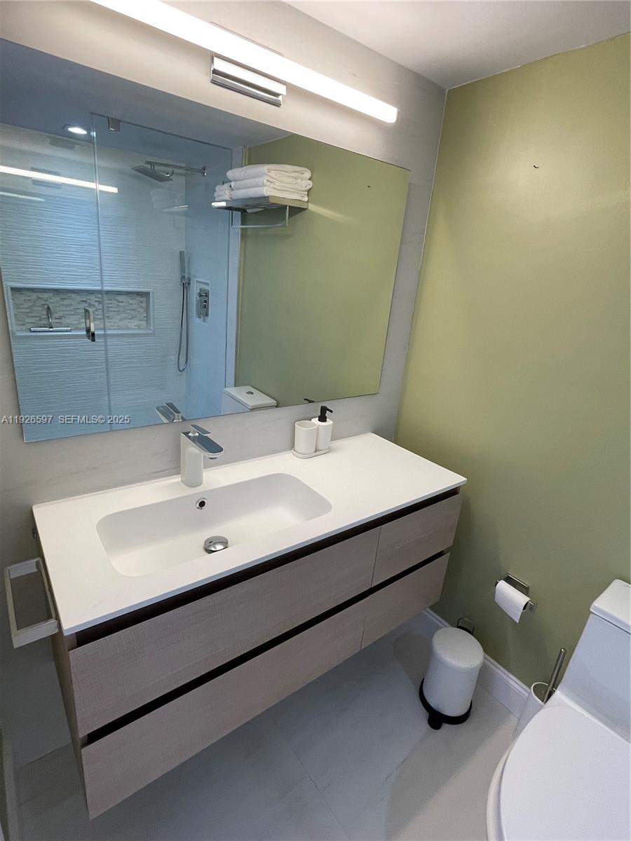 8911 Collins Avenue, Unit 1201 Surfside, FL 33154 - Photo 16 of 27 a bathroom with a sink mirror and toilet
