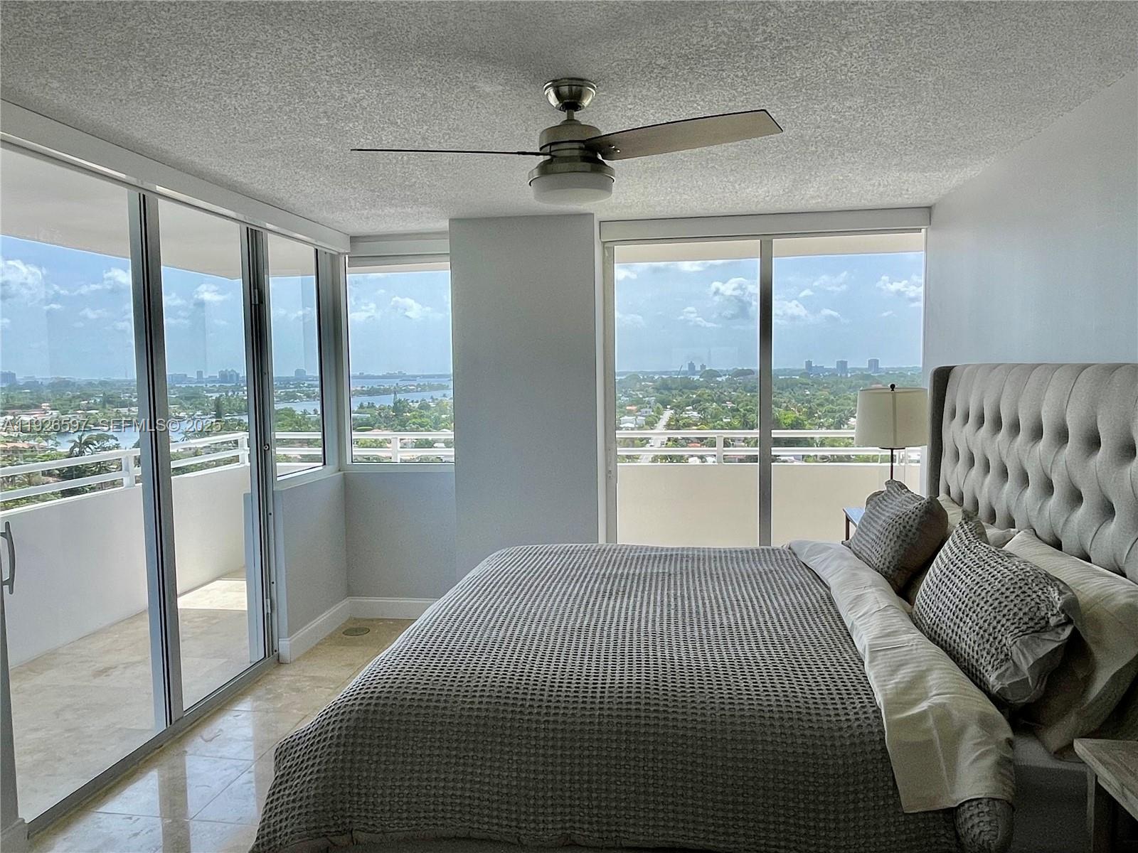 8911 Collins Avenue, Unit 1201 Surfside, FL 33154 - Photo 18 of 27 a bedroom with a large bed and a large window