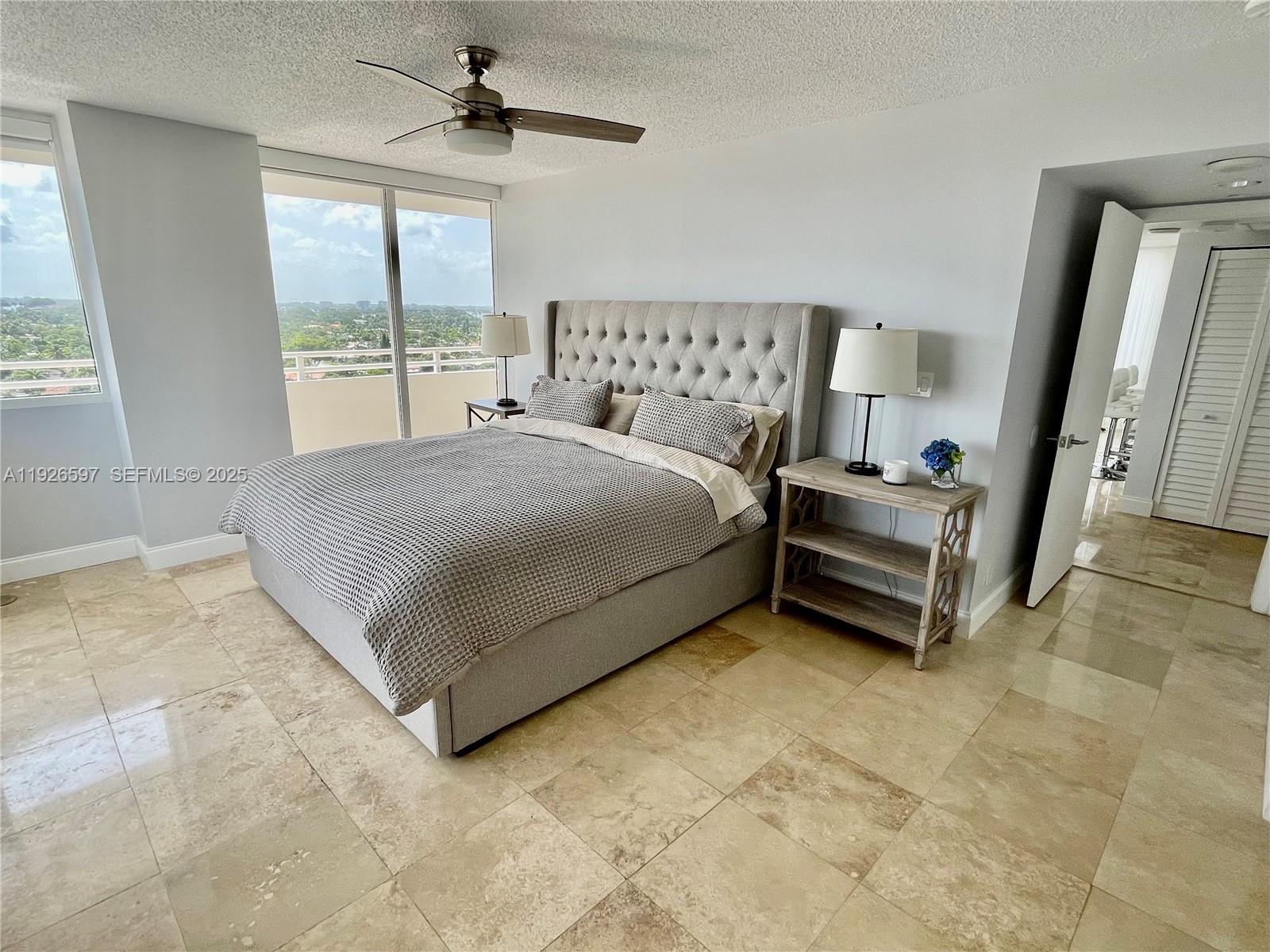 8911 Collins Avenue, Unit 1201 Surfside, FL 33154 - Photo 19 of 27 a spacious bedroom with a bed and a window