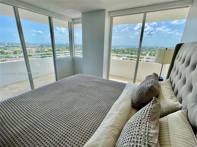 a bedroom with a bed and a large window