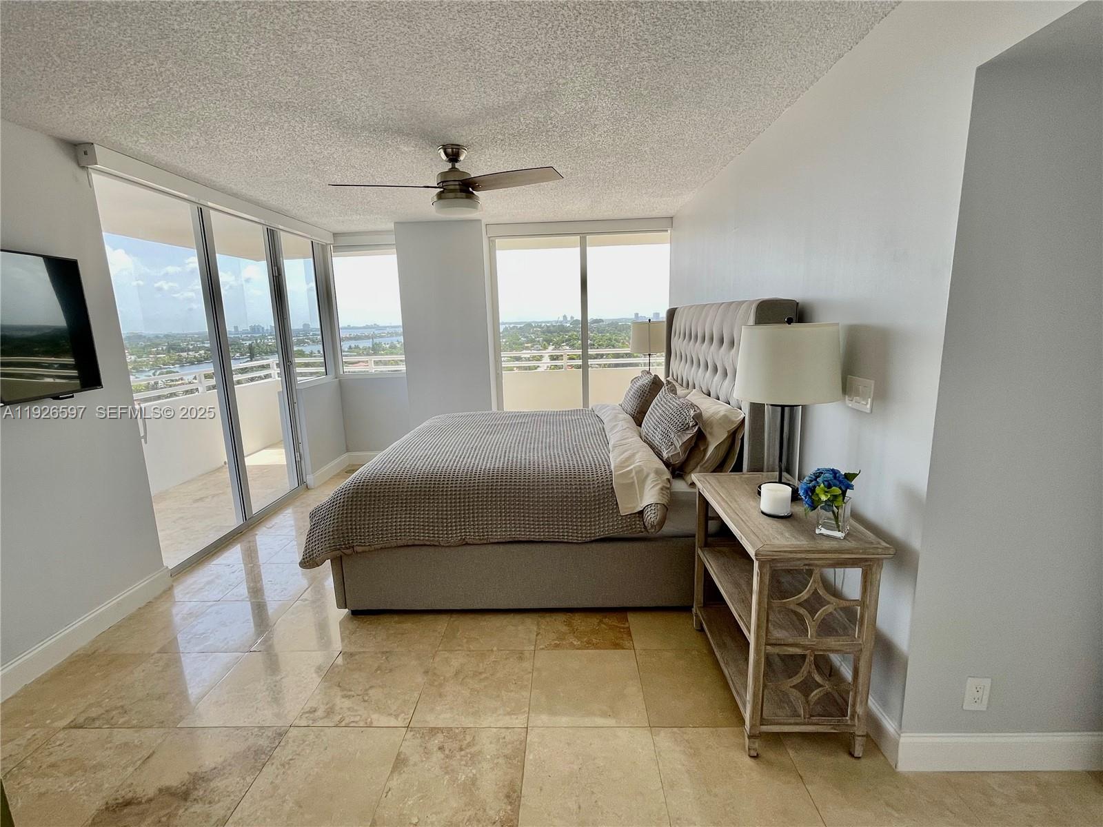 8911 Collins Avenue, Unit 1201 Surfside, FL 33154 - Photo 21 of 27 a bedroom with a bed and large window