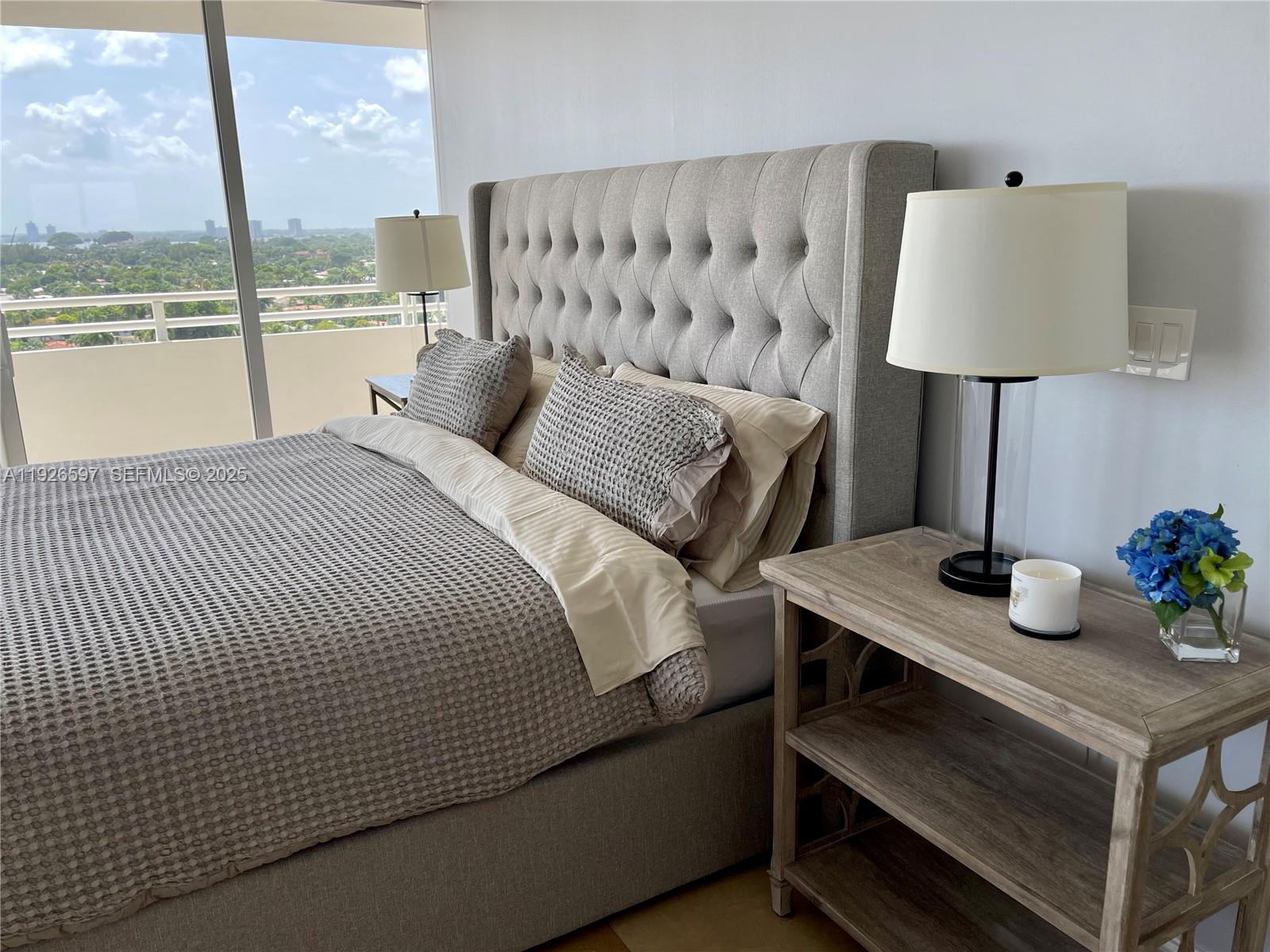 8911 Collins Avenue, Unit 1201 Surfside, FL 33154 - Photo 22 of 27 a bed room with a bed and a table