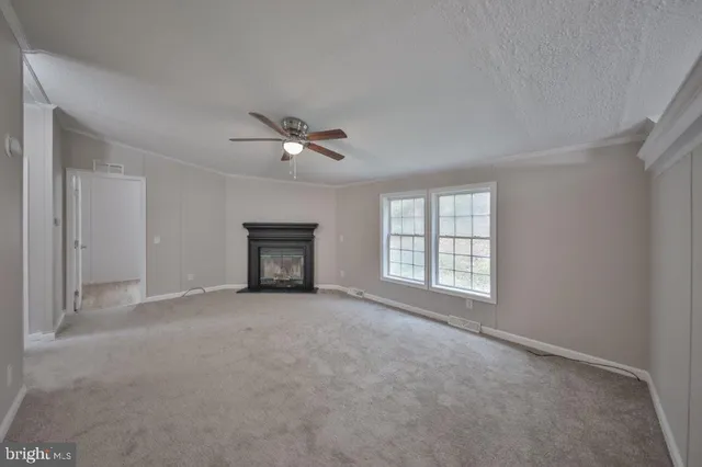 a view of an empty room with a fireplace and a window