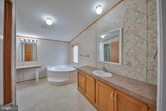 a spacious bathroom with a double vanity sink toilet mirror and bathtub