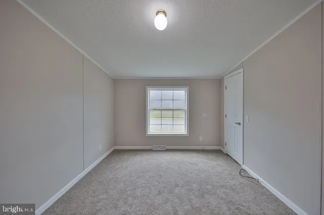a view of an empty room with a window and a lamp