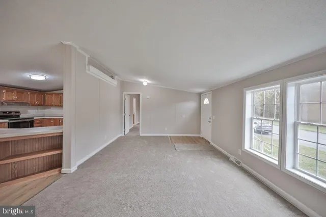 a view of an empty room with a kitchen