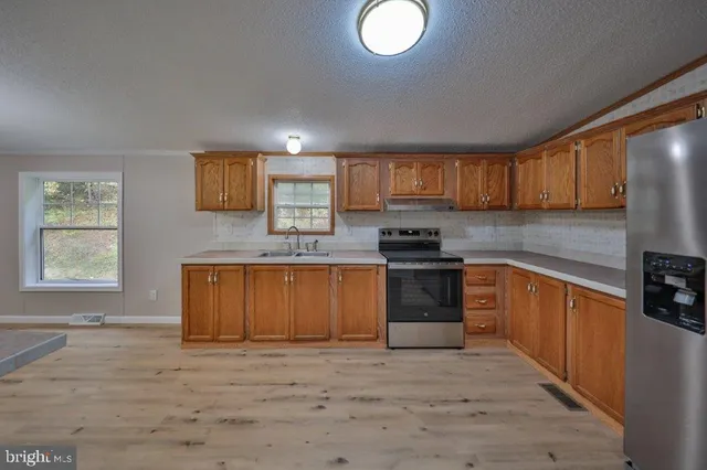 a kitchen with stainless steel appliances granite countertop a stove a sink and a refrigerator