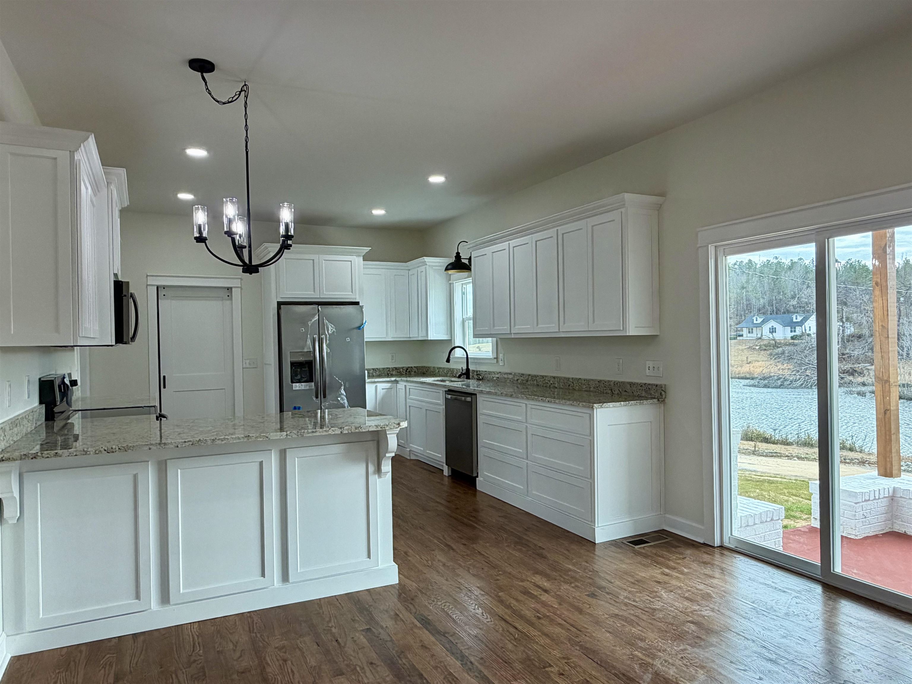172 New Bethel Road Selmer, TN 38375 - Photo 9 of 30 a kitchen with kitchen island granite countertop a sink a counter space appliances and cabinets