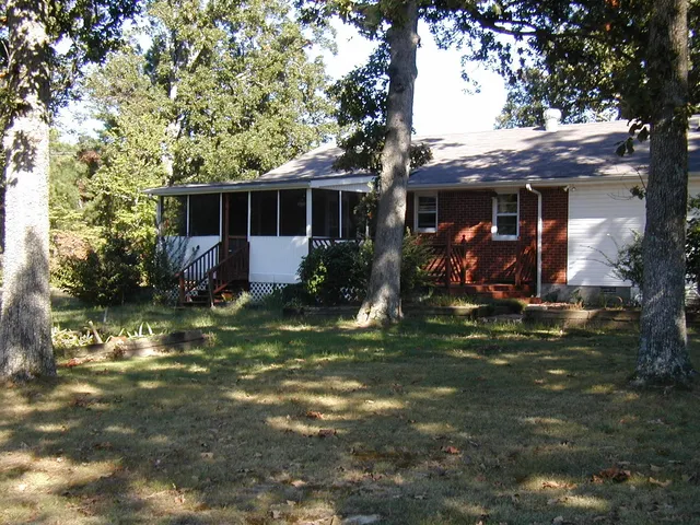 a view of a house with yard and a large tree