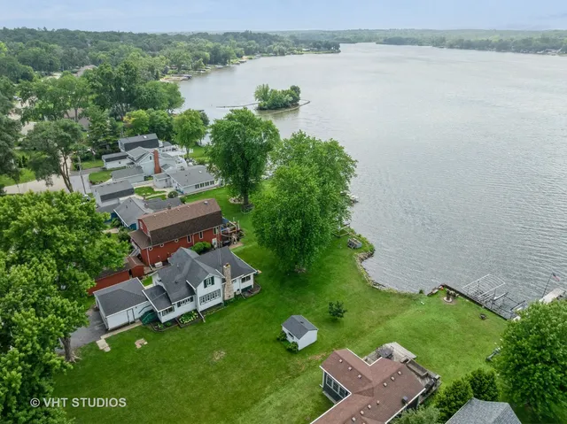 an aerial view of a house with outdoor space and lake view