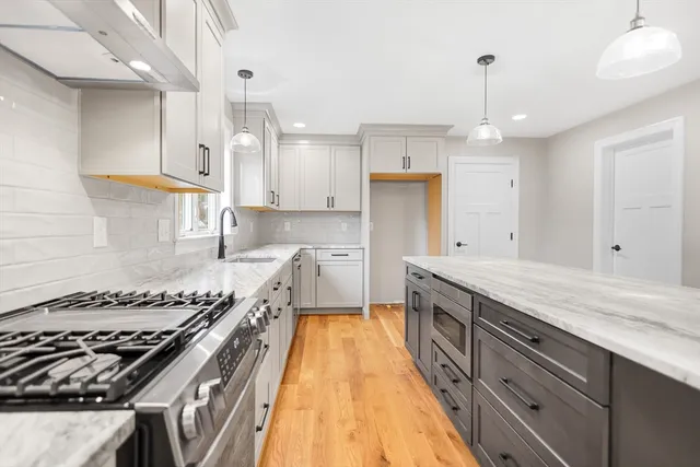 a kitchen with a stove a sink a refrigerator and window