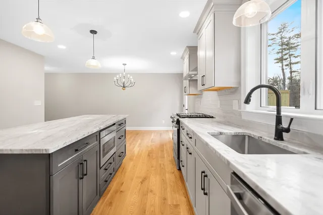 a kitchen with a sink a counter space appliances and cabinets