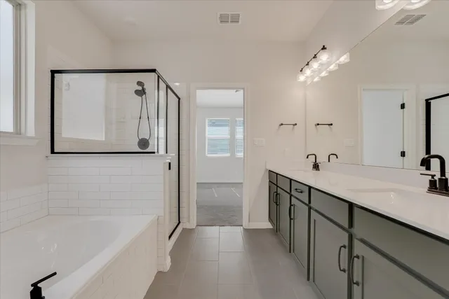 a bathroom with a double vanity sink mirror and shower