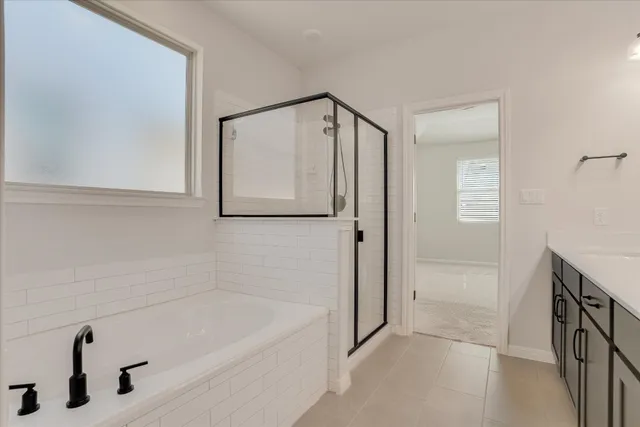 a bathroom with a tub a sink and mirror
