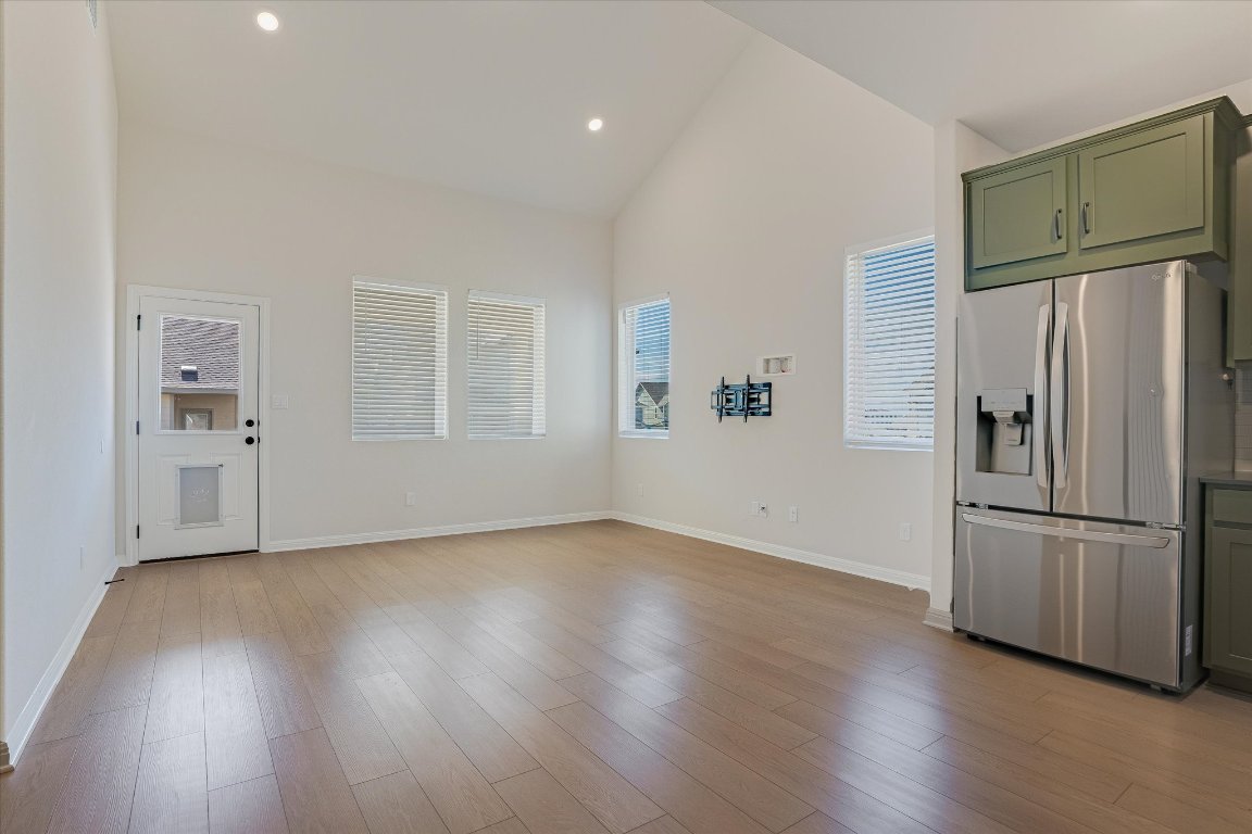 168 Kings Cyn Drive Dripping Springs, TX 78620 - Photo 6 of 25 a view of a kitchen with wooden floors and refrigerator