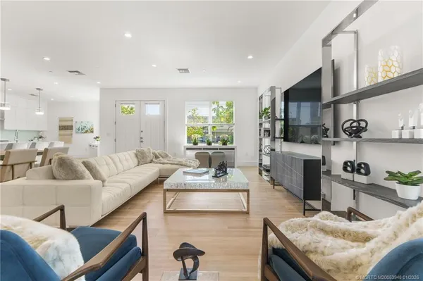 a kitchen with stainless steel appliances kitchen island granite countertop a table chairs in it and wooden floors