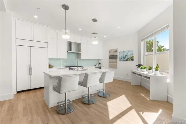 a kitchen with kitchen island white cabinets and stainless steel appliances