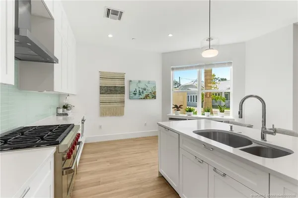 a utility room with stainless steel appliances granite countertop a stove and a refrigerator