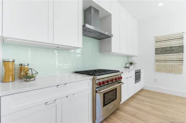 a kitchen with stainless steel appliances a sink a stove and a wooden floors