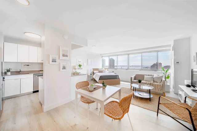 a living room with furniture and a large window with kitchen view