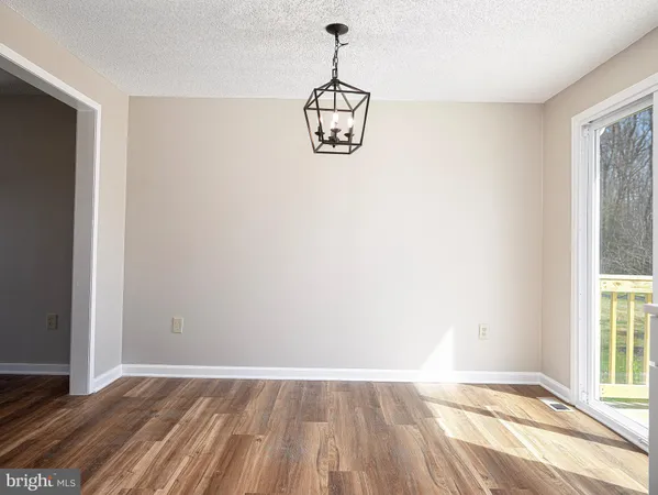 a view of a room with wooden floor exposed radiator and windows