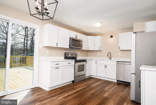 a kitchen with cabinets stainless steel appliances a sink and a window