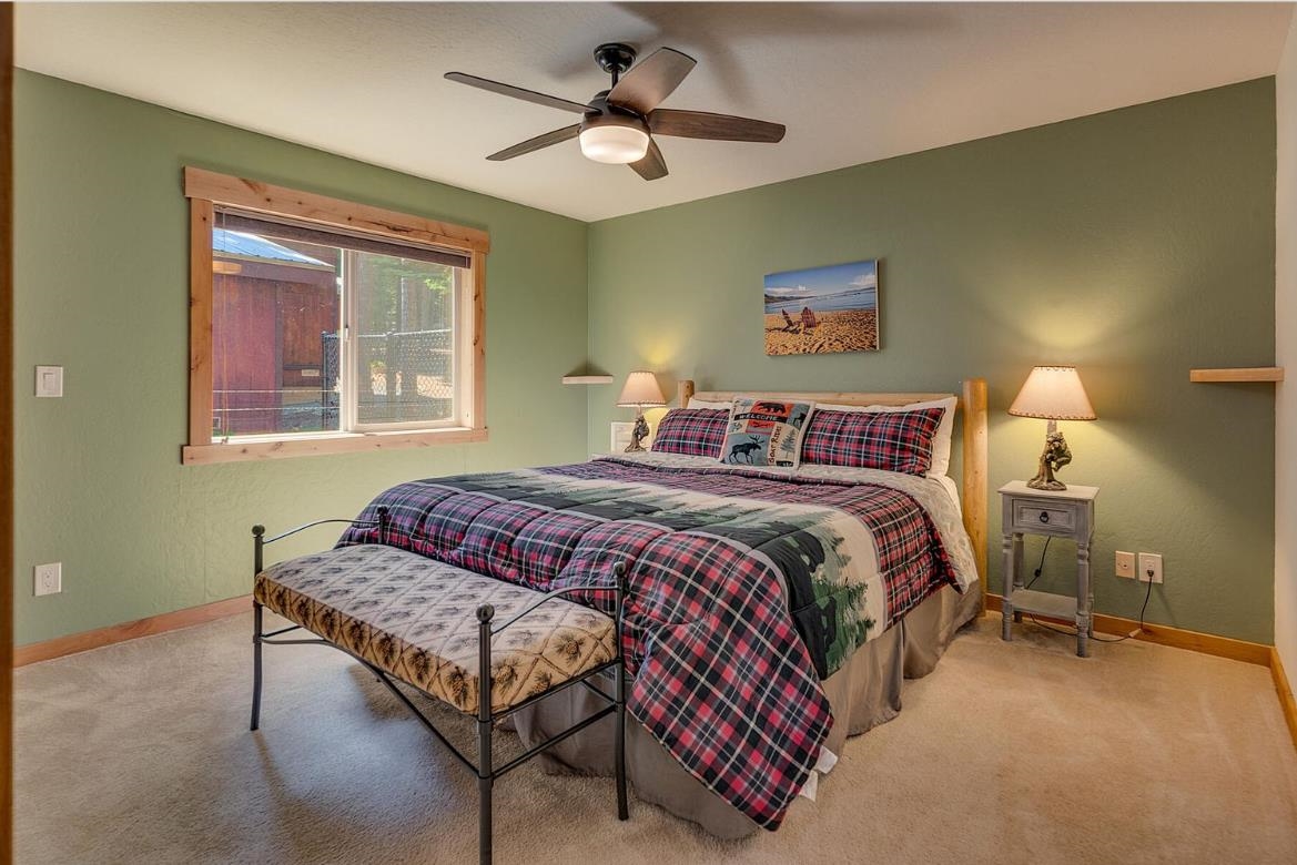 730 Cascade Circle Homewood, CA 96141 - Photo 16 of 22 a bedroom with a bed a chandelier and a window